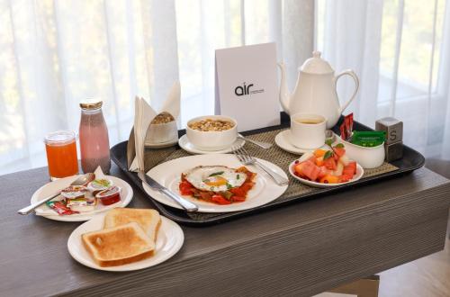 a tray of breakfast foods on a table at AIR by Ahuja Residences in Gurgaon