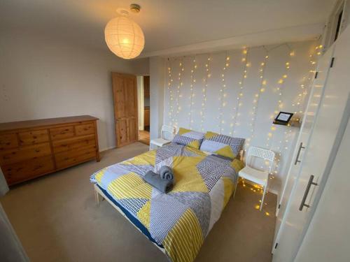 sypialnia z łóżkiem i oświetleniem na ścianie w obiekcie Flat by Victoria park - with balcony w Londynie
