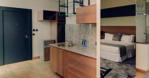 a hotel room with a bed and a sink at OTIA HOTEL in Maputo