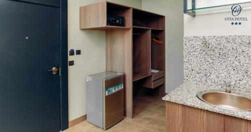a bathroom with a sink and a refrigerator in it at OTIA HOTEL in Maputo