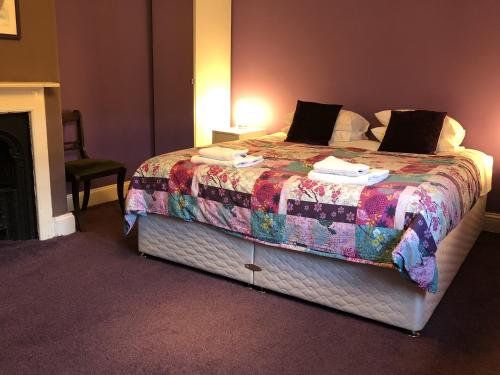 a bedroom with a large bed in a room with a fireplace at Circles Guest House in Pewsey