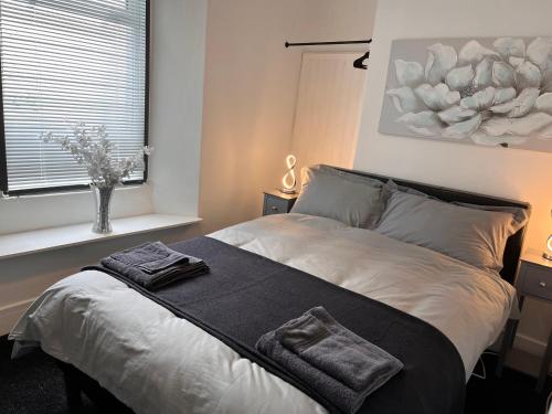 um quarto com uma cama com duas toalhas em Sandy Toes : Relaxing Contemporary Victorian Apartment 10 mins to Beach em Torquay