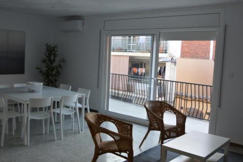 ein Esszimmer mit einem Tisch und Stühlen sowie einem Balkon in der Unterkunft Roses Center 6 in Roses