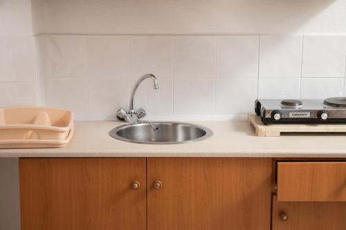 a kitchen counter with a sink and a stove at Aphrodite Apartments in Kalyves