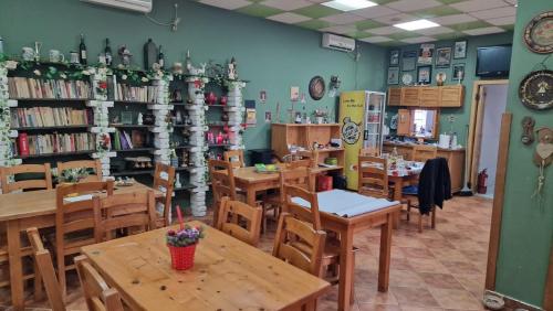 a dining room with wooden tables and shelves of books at Pensiunea Brian in Moieciu de Jos