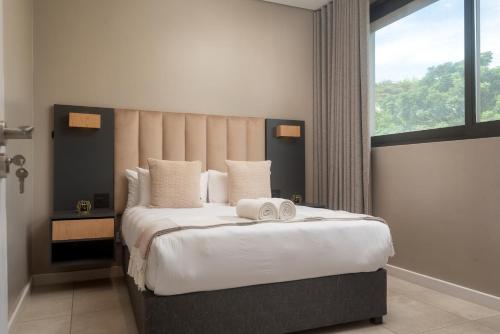 a bedroom with a large bed with two towels on it at Zimbali Lakes Boulevard Suites in Ballito