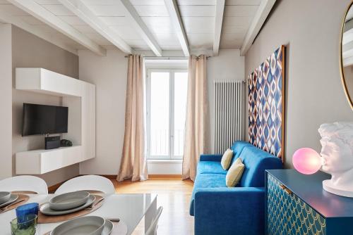a living room with a blue couch and a table at REGO APARTMENTS - Boutique Aparthotel with some off-site apartments in a Charming Historic District close to Upper Town in Bergamo