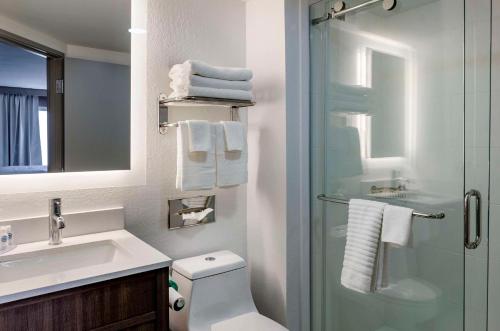 a bathroom with a shower and a toilet and a sink at Comfort Inn in Beckley