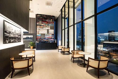 a restaurant with tables and chairs and large windows at Best Western Chatuchak in Bangkok