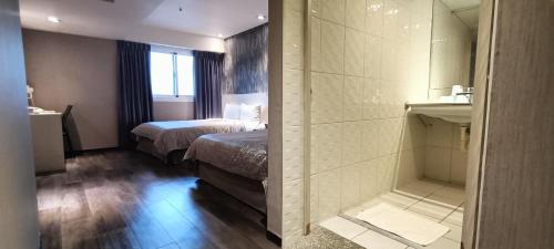 um quarto de hotel com uma cama e um chuveiro em Palmer Hotel em Taichung