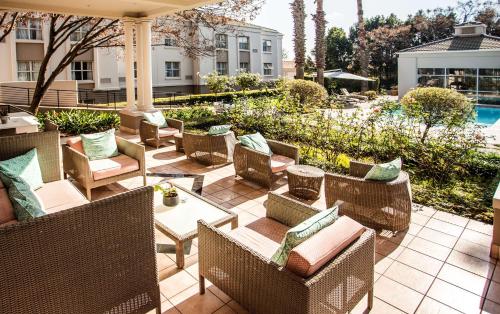 a patio with wicker chairs and tables and a pool at Garden Court Morningside Sandton in Johannesburg