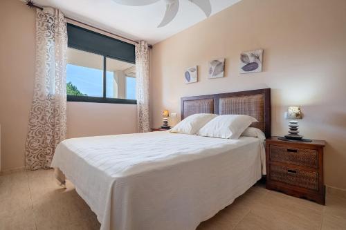 um quarto com uma cama grande e uma janela em Costa Linda 313 em L'Hospitalet de l'Infant