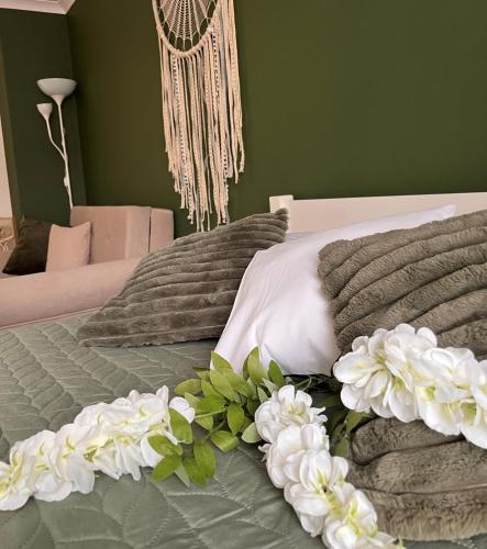 Apartament na Starówce Boho في بيشتنا: غرفة نوم مع سرير مع زهور بيضاء عليه