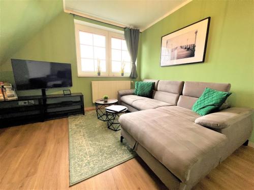 Una sala de estar con un sofá y un televisor de pantalla plana. en Ferienwohnung Rabenblick, en Binz