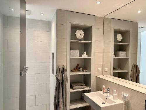 La salle de bains est pourvue d'un lavabo et d'une douche. dans l'établissement MEOS 2 -Zentrum-Hofblick-Gym-Netflix, à Leipzig