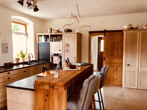 a kitchen with a wooden table and some chairs at Der Hof am Wald in Weichselbaum