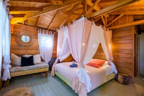 a bedroom with a bed and curtains in a room at King Louie and Mowgli in Saint-Paul-de-Vence