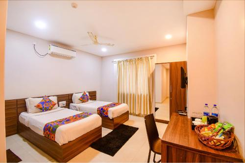 Habitación de hotel con 2 camas y escritorio en FabHotel Royal Crystal, en Bhubaneshwar