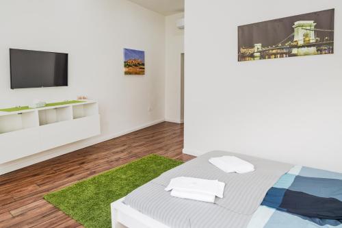 1 dormitorio con 1 cama y TV en la pared en Boutique HomeR374 Studio Apartment #freeparking, en Budapest