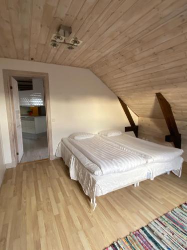 Cama en habitación con techo de madera en Hotell Villa Borgen, en Visby