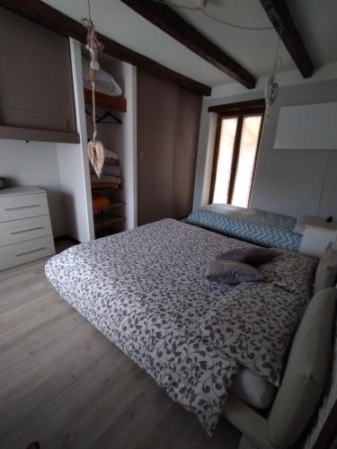 1 dormitorio con 1 cama con edredón blanco y negro en La Ghianda con terrazza, en Cossogno