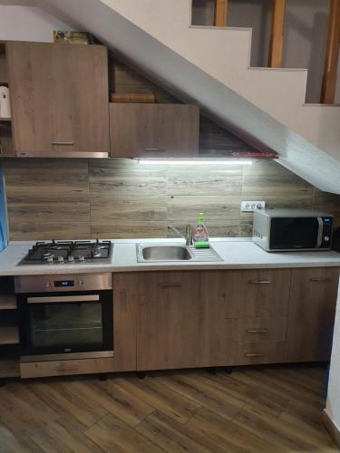 uma cozinha com um fogão, um lavatório e uma escadaria em Casa Miruna & Noris em Bran