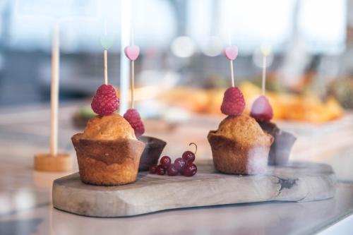 three muffins with raspberries on top on a table at Villa Giada Resort in Imperia