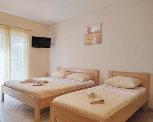 two beds sitting next to each other in a room at Apartments Draženka in Neum