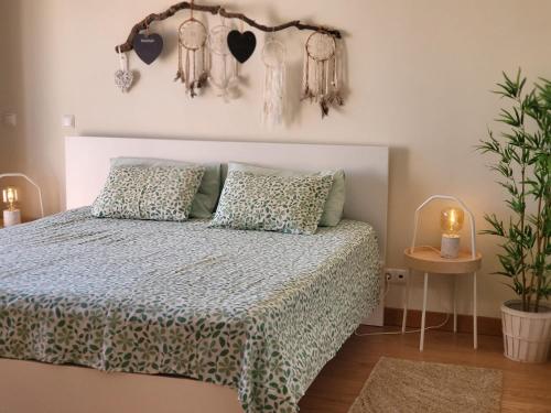 ein Schlafzimmer mit einem Bett und einem Tisch mit einer Pflanze in der Unterkunft Miamar House 6 Sesimbra in Sesimbra