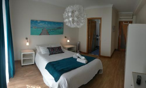 a bedroom with a large bed with a blue blanket at MAHGIC Beach Apartment in Cabanas de Tavira