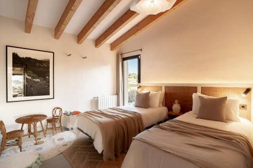 - une chambre avec 2 lits, une table et une fenêtre dans l'établissement Vista Verde, à Sineu