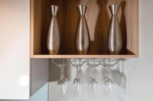 a wooden shelf with silver vases and wine glasses at Pool Access Condo Bangtao Beach in Bang Tao Beach