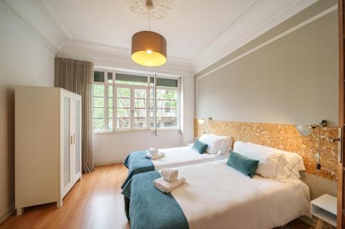 a bedroom with two beds and a large window at Feel Porto Downtown Apartments & Studios in Porto