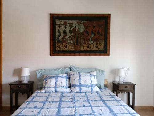 エル・メダノにあるApartamento con vistasのベッドルーム1室(壁に絵画が描かれたベッド1台付)
