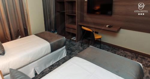 a hotel room with a bed and a desk and a chair at OTIA HOTEL in Maputo
