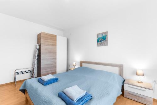 1 dormitorio con 1 cama azul y 2 toallas en Apartments Morena, en Novigrad Istria