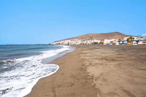 a sandy beach with houses and the ocean at Casa Valentina in Tuineje