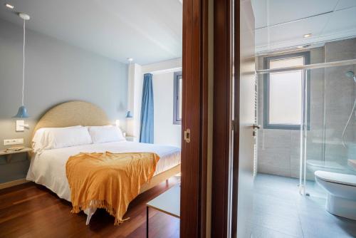 sypialnia z łóżkiem oraz łazienka z wanną w obiekcie Aspasios Diagonal Art w Barcelonie
