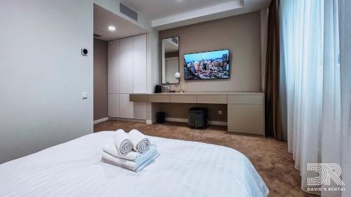 a hotel room with a bed and a tv on the wall at DAVID'S RENTAL ROOMs in Bucharest