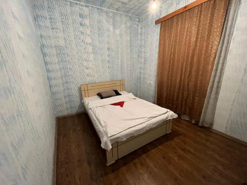 Cette petite chambre comprend un lit avec une chemise rouge. dans l'établissement Farmer's Guest House, à Telavi