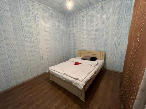 een kleine slaapkamer met een bed in een kamer met behang bij Farmer's Guest House in Telavi