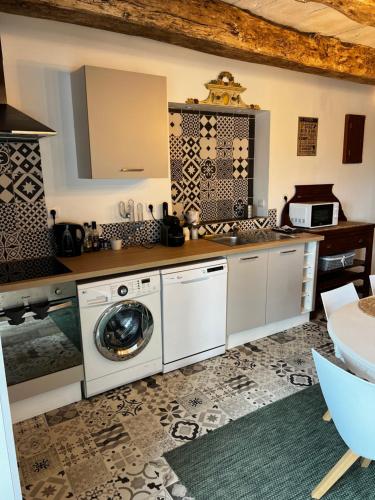 a kitchen with a washer and a washing machine at Domaine de la Ville Chérel, maison en pierre in Pontorson