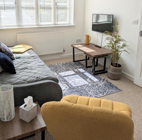 a living room with a bed and a couch and a table at Studio Apartment North Cardiff in Cardiff