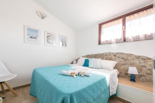 a bedroom with a bed with a blue blanket at Porto Luna in Villasimius