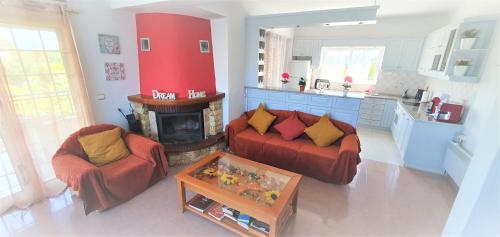 sala de estar con sofá rojo y chimenea en Vacation and Relaxation Home Oropos, en Néa Palátia