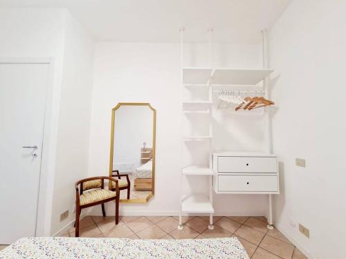 um quarto com um espelho, uma cadeira e uma cómoda em Appartamento San Giorgio em Lovere