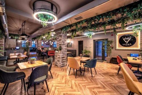 a restaurant with tables and chairs and plants on the walls at Casa Vatra Radauti in Rădăuţi