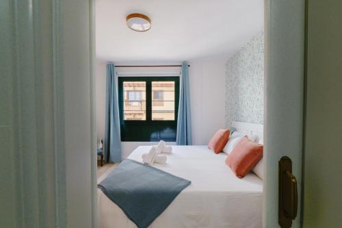 a bedroom with a white bed and a window at Acogedor apartamento en Puerto de la Cruz in Puerto de la Cruz