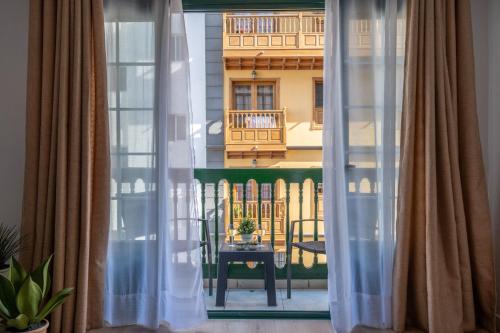 uma vista para uma varanda a partir de uma janela com cortinas em Acogedor apartamento en Puerto de la Cruz em Puerto de la Cruz
