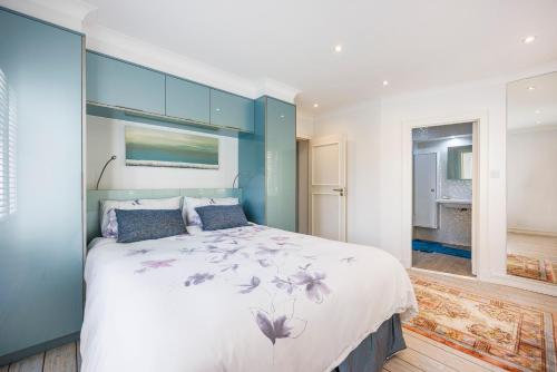 a bedroom with a large bed with a blue wall at Londonese House in Chelsea in London